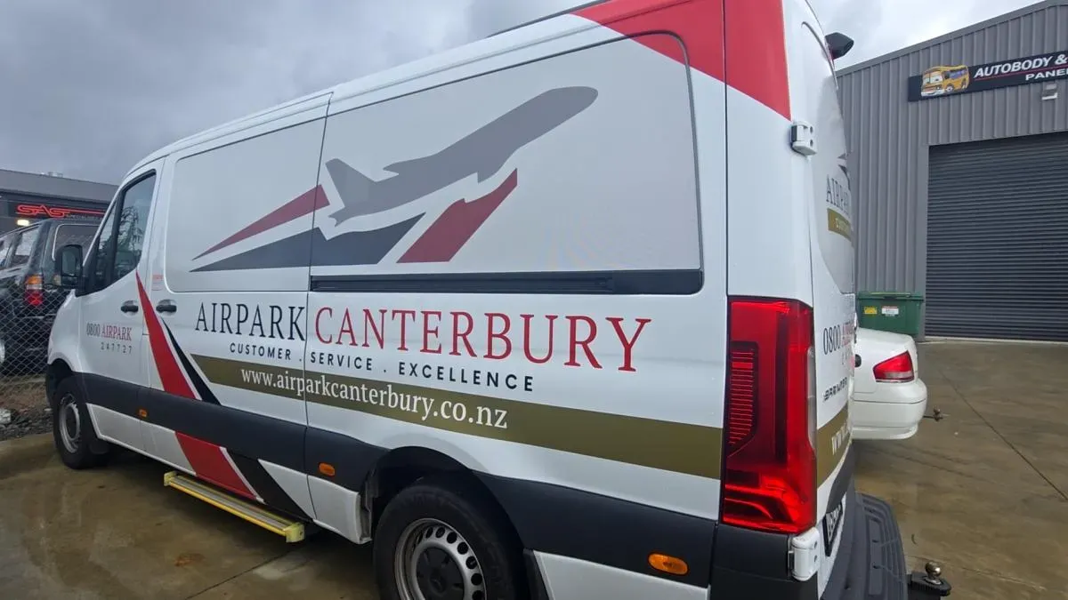A signwritten courier van outside the workshop