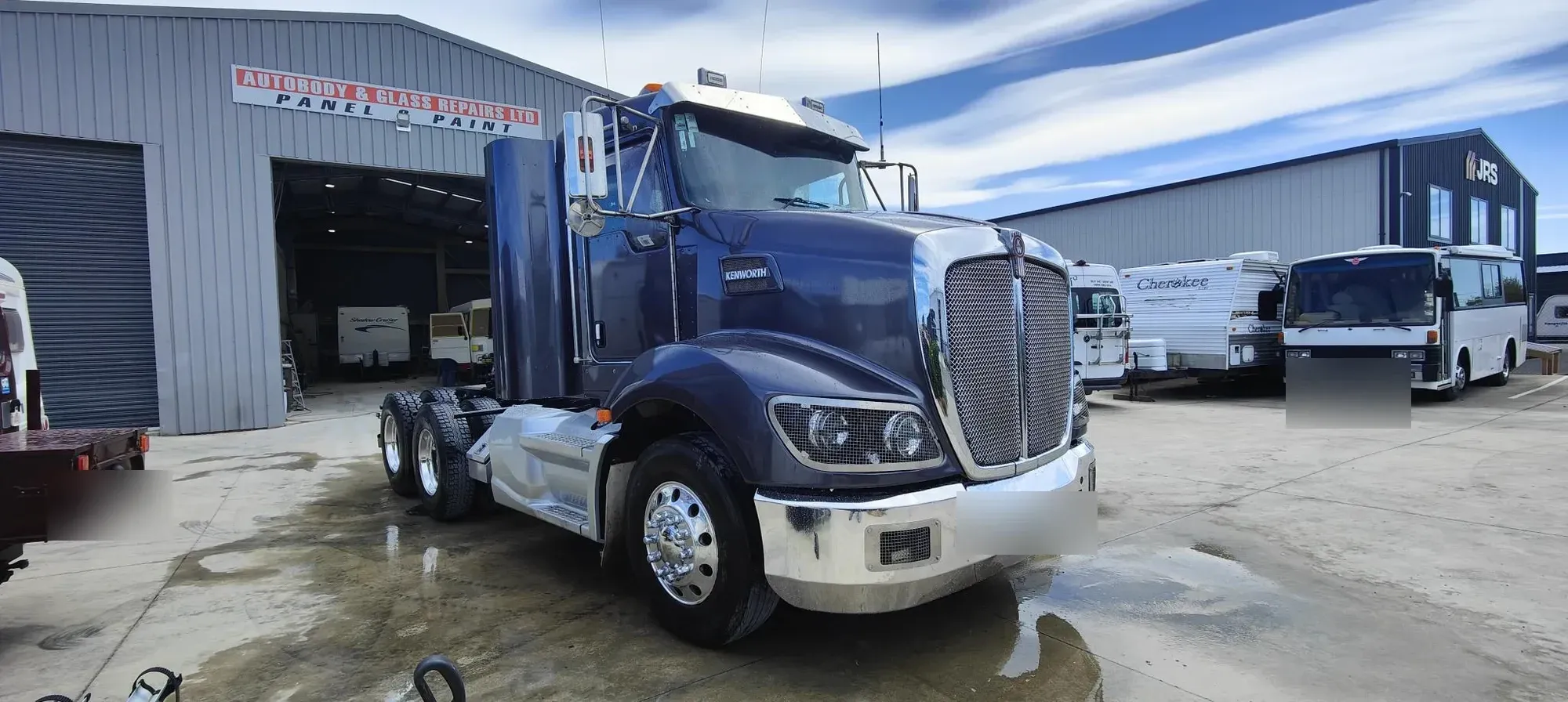 The same Kenworth finished in deep metallic navy outside the Belfast workshop