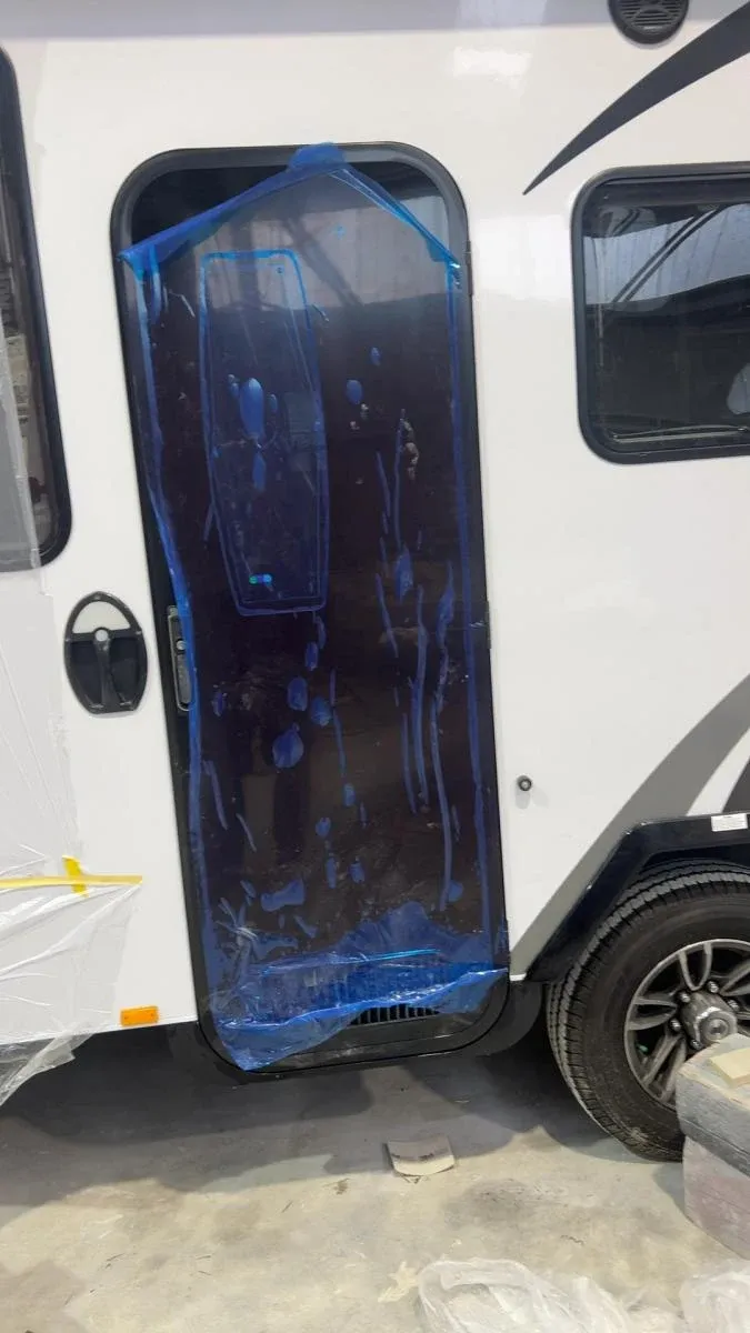 A Jayco caravan door masked up mid-rebuild