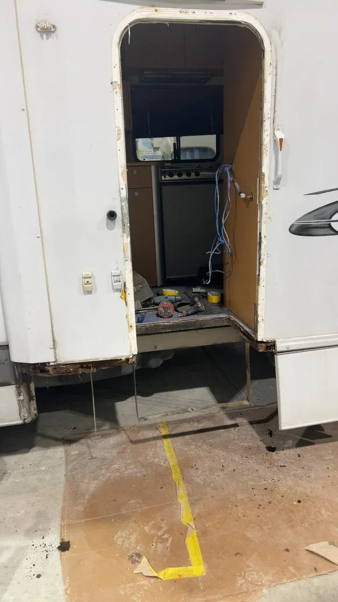 A motorhome entry door and frame rotted out and stripped back