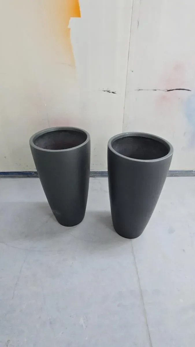 A pair of planter pots primed grey in the spray booth