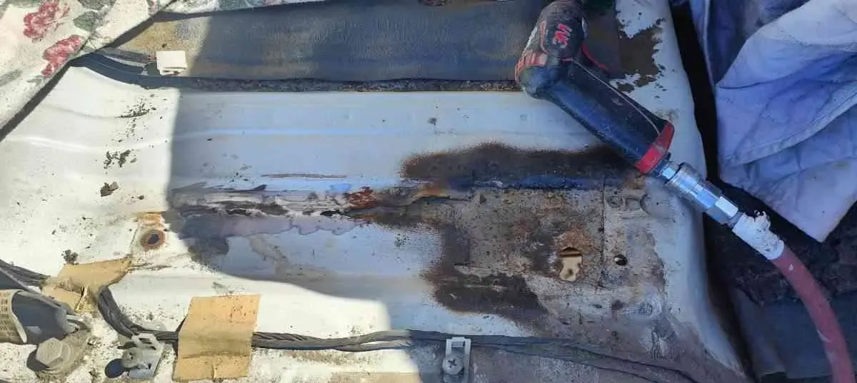 A rusted floor pan cut back for repair