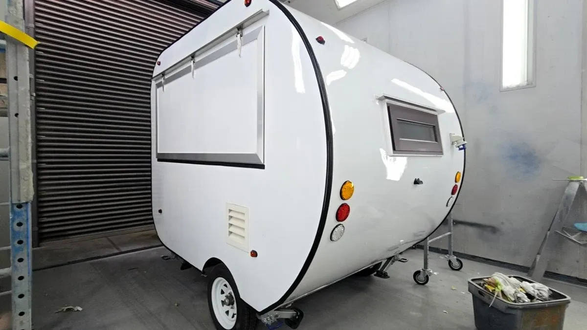 A teardrop trailer in bare white before its finish coat