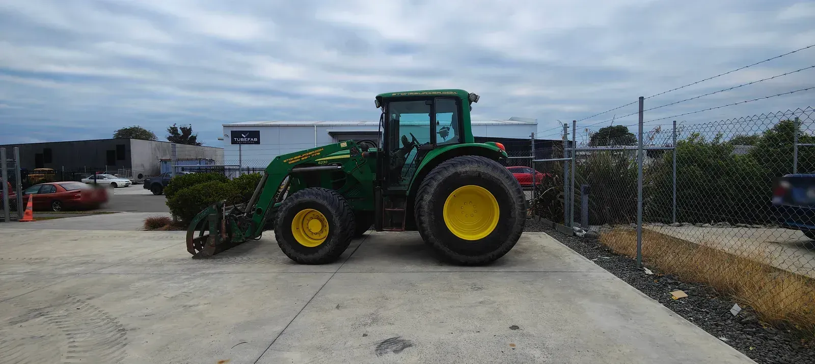 The same John Deere tractor finished, back outside the workshop